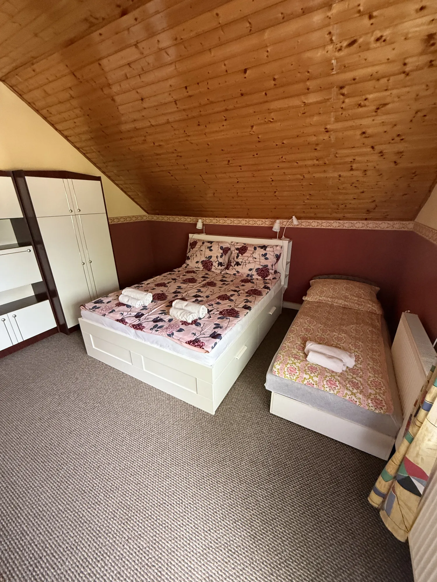 Tetőtéri hálószoba a Beáta Apartmanházban franciaággyal és külön ággyal